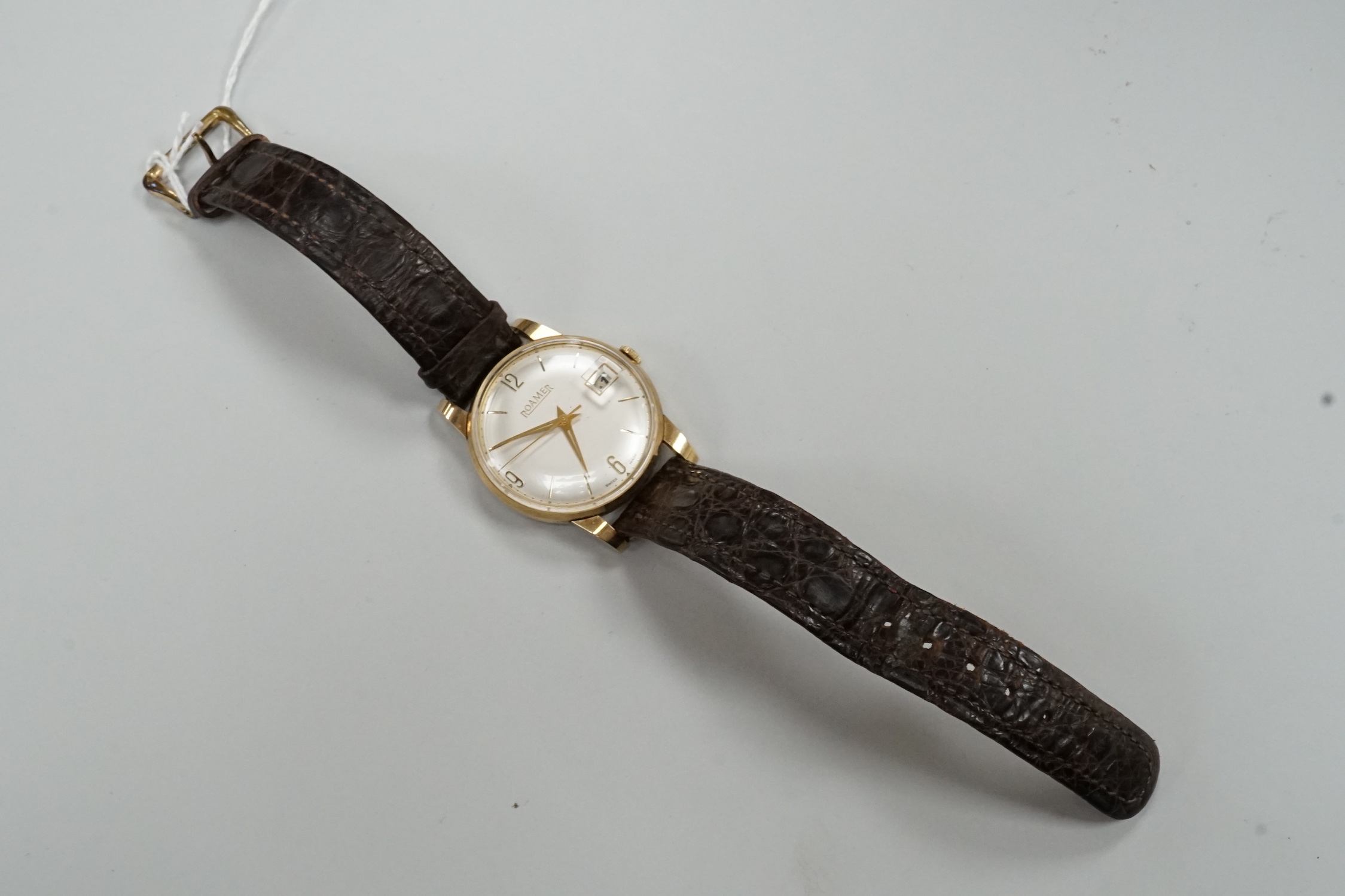 A gentleman's yellow metal Roamer manual wing wrist watch, with case back inscription, on a leather strap.